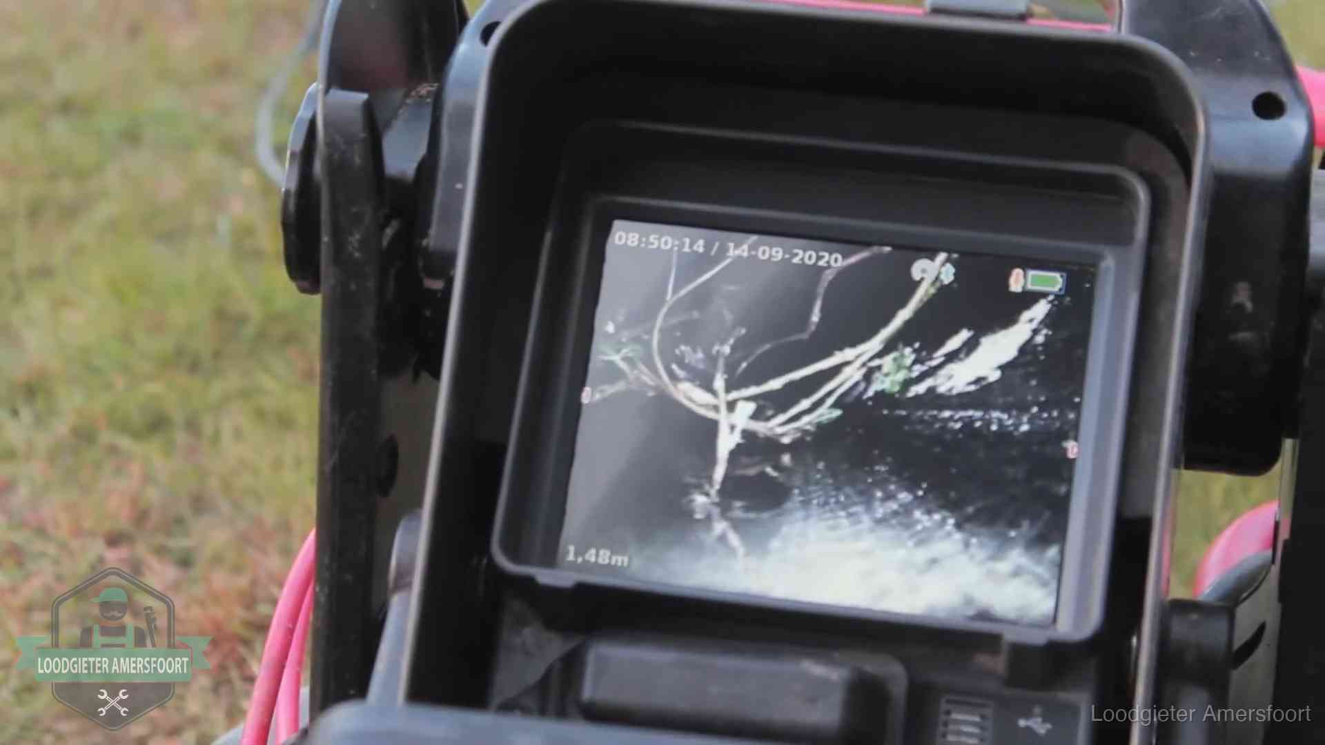 Monitor van een rioolcamera toont wortelingroei in de rioolbuis bij een woning in Amersfoort