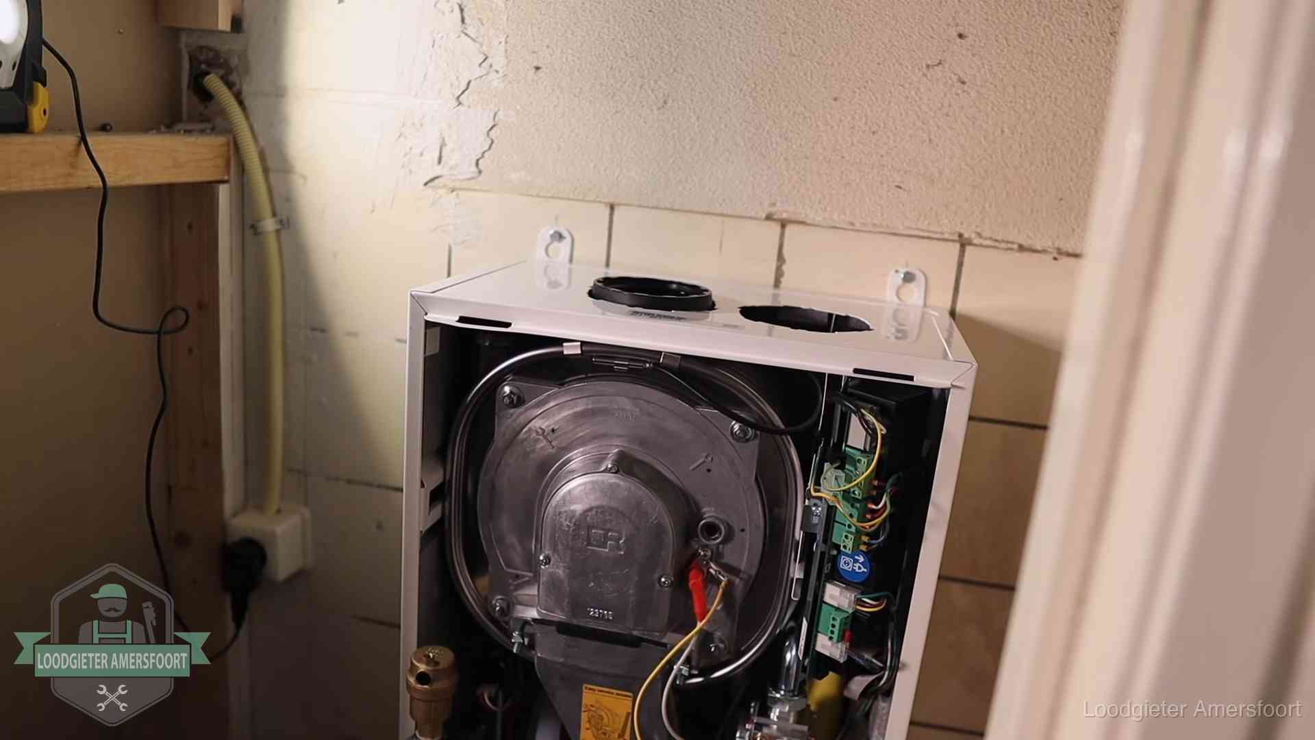 Geopende cv-ketel tijdens een onderhoudsbeurt in Amersfoort, met brander en warmtewisselaar zichtbaar