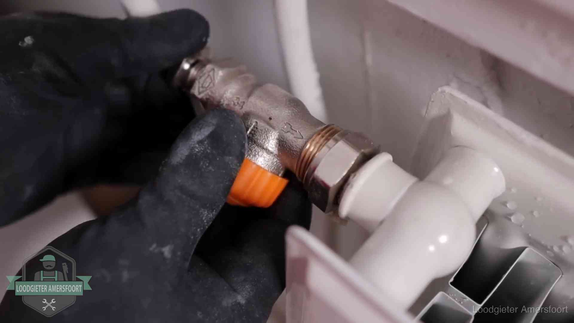 Thermostaatkraan wordt gemonteerd op een radiator in Amersfoort voor het stookseizoen