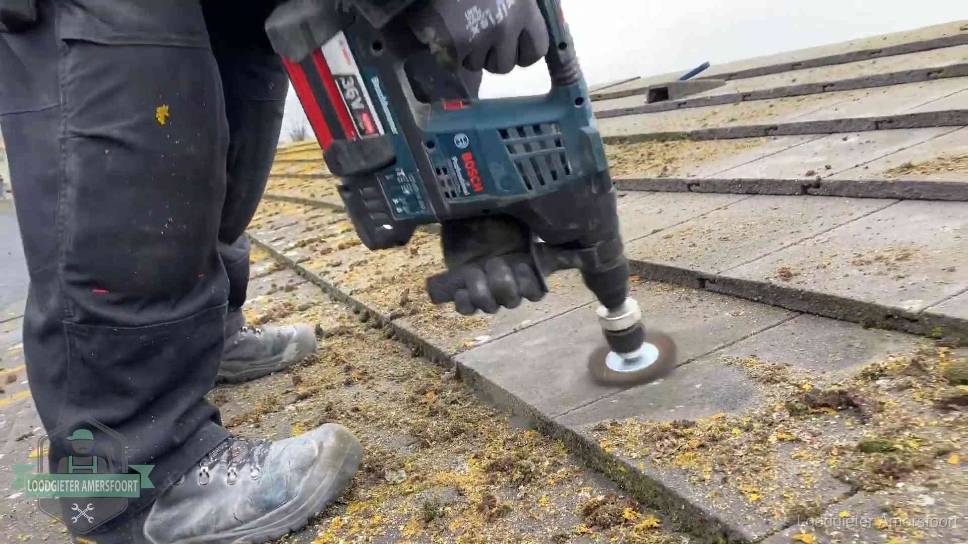 Betonnen dakpannen worden machinaal gereinigd tijdens dakonderhoud in Amersfoort