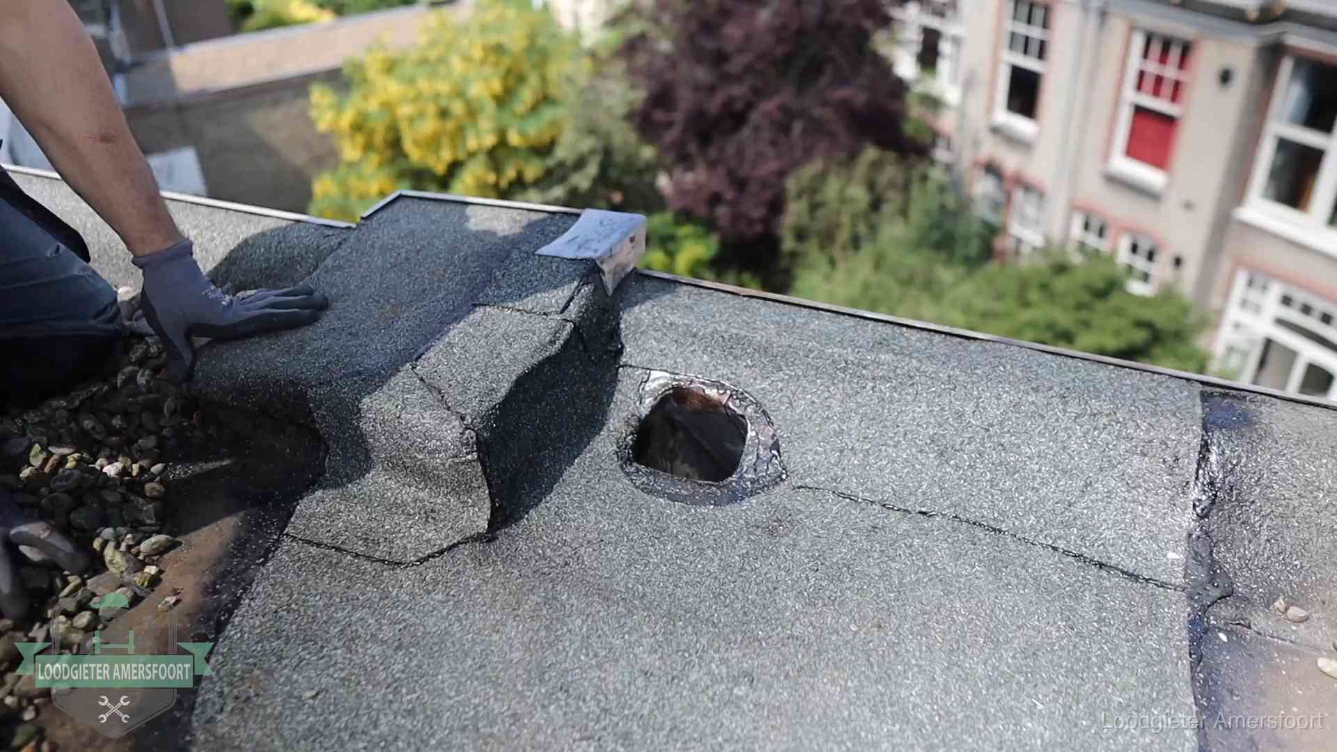 Loodgieter inspecteert een beschadigd bitumen plat dak tijdens een daklekkage-inspectie in Amersfoort