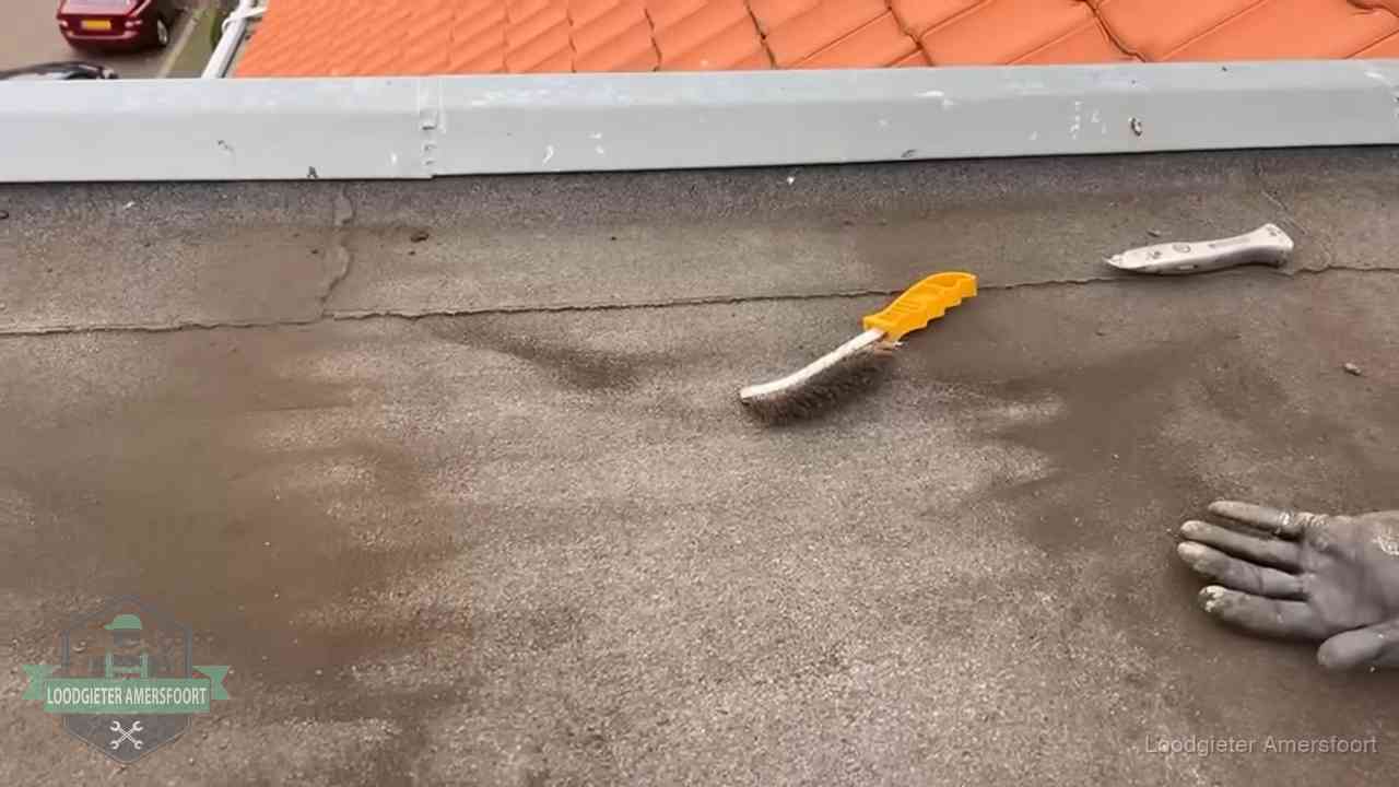 Dakdekker bereidt een bitumen plat dak voor op reparatie bij de daktrim in Amersfoort