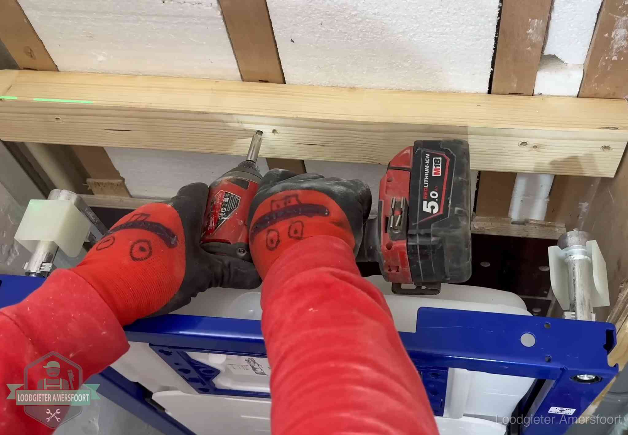 Monteur bevestigt een inbouwreservoir voor een hangend toilet in Amersfoort