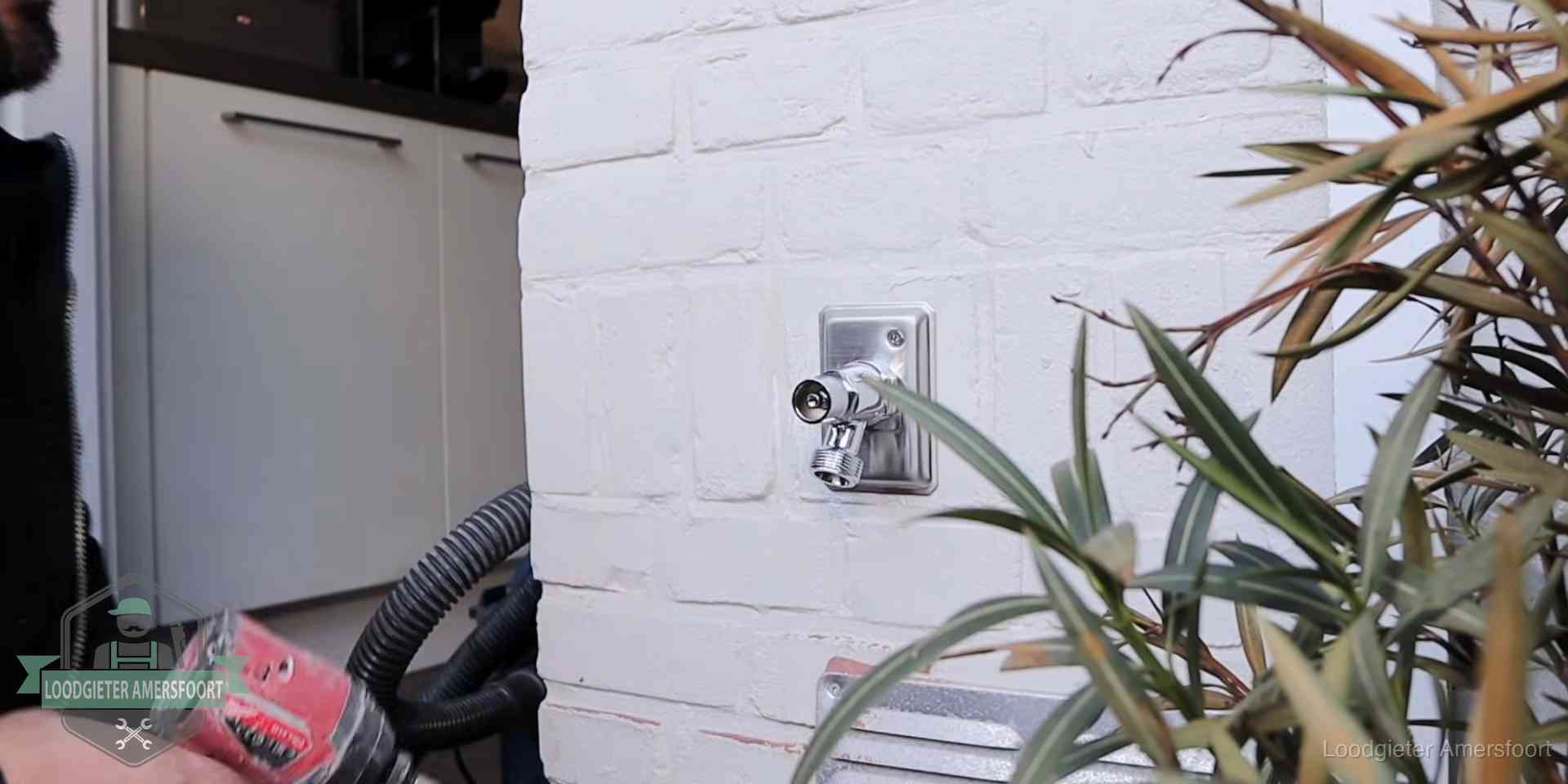 Chromen kraan op een muurplaat bij een woning in Amersfoort, dichtdraaien is stap een van de lektest