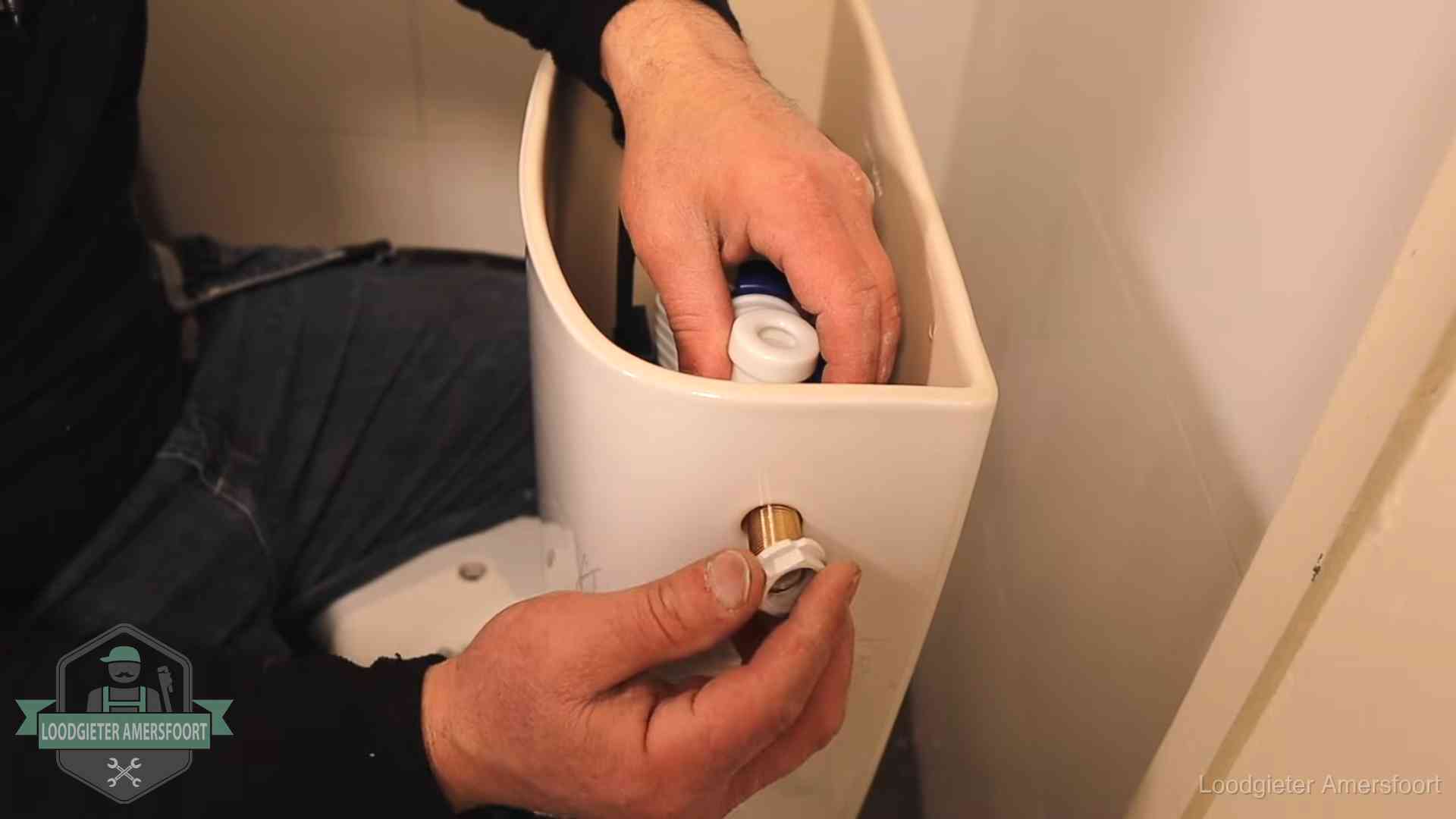 Loodgieter monteert de vlotterkraan van een stortbak bij een toilet in Amersfoort