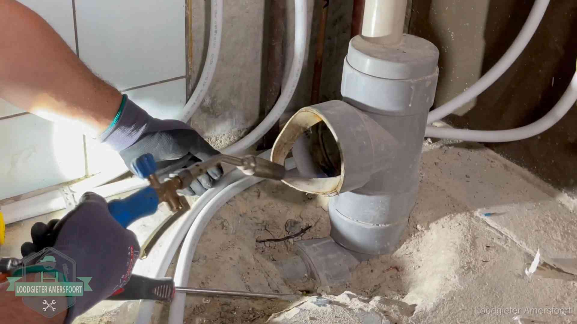 Vakmanschap van onze loodgieters in Amersfoort Loodgieter werkt met brander en messing kraanwerk aan leidingen in Amersfoort