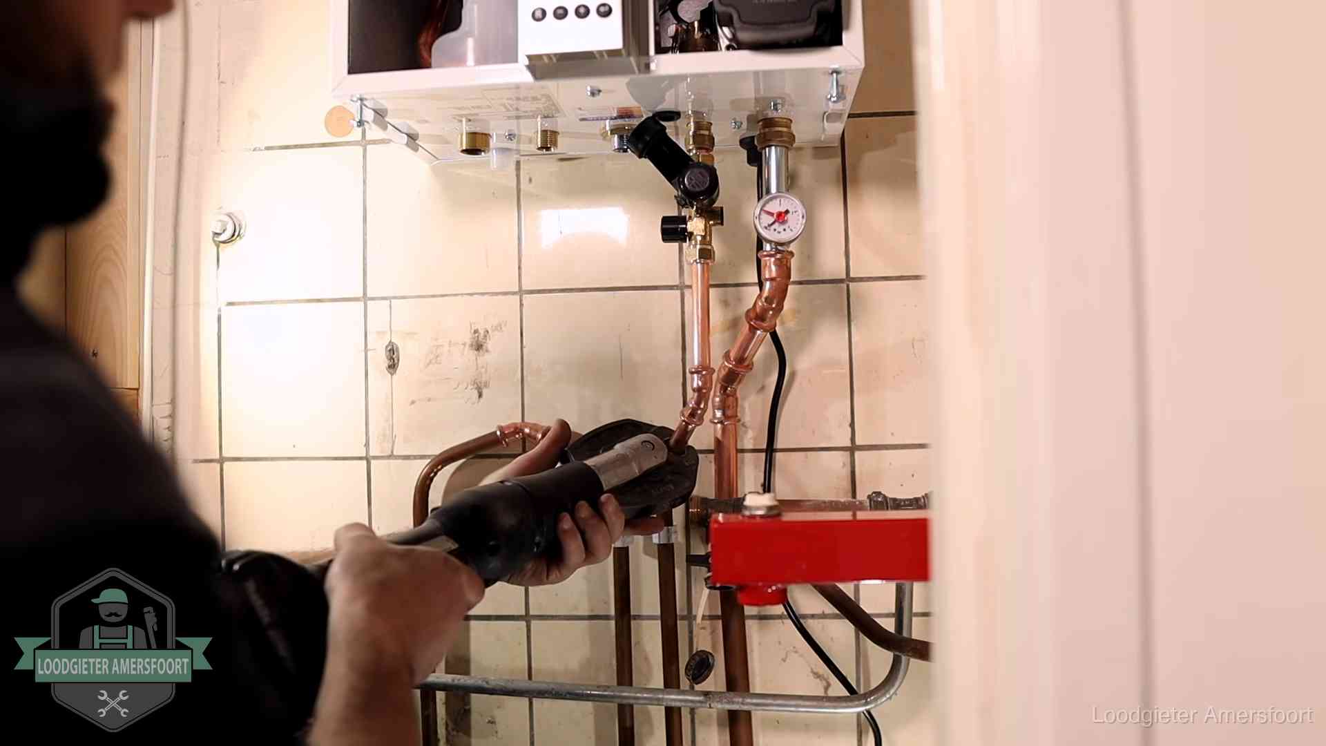 Monteur werkt aan de leidingen onder een cv-ketel in Amersfoort