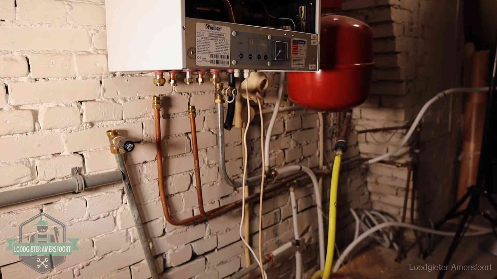 Verouderde cv-ketel met een wirwar van oude leidingen in een woning in Amersfoort
