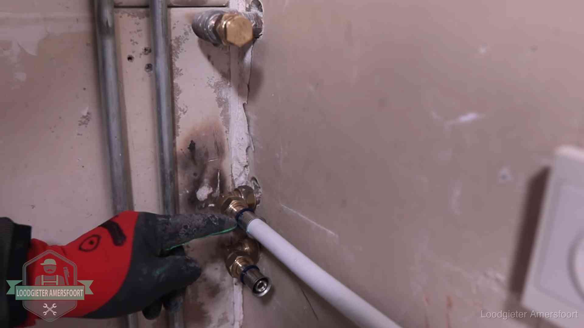 Garantie op loodgieterswerk in Amersfoort Loodgieter wijst de persfitting op nieuwe muuraansluitingen aan in een woning in Amersfoort