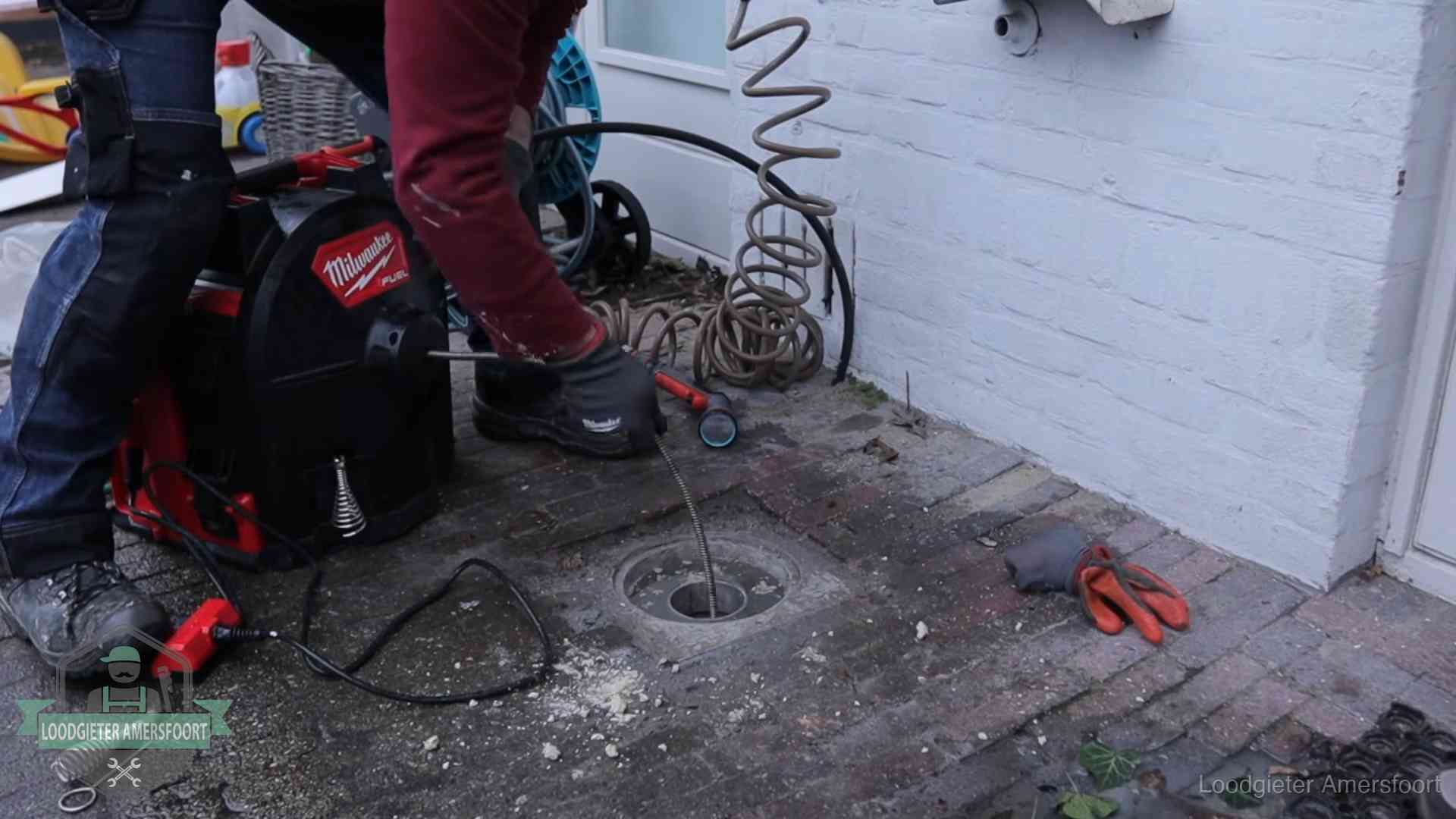 Spiraalmachine bij een ontstoppingsputje in de bestrating in Amersfoort