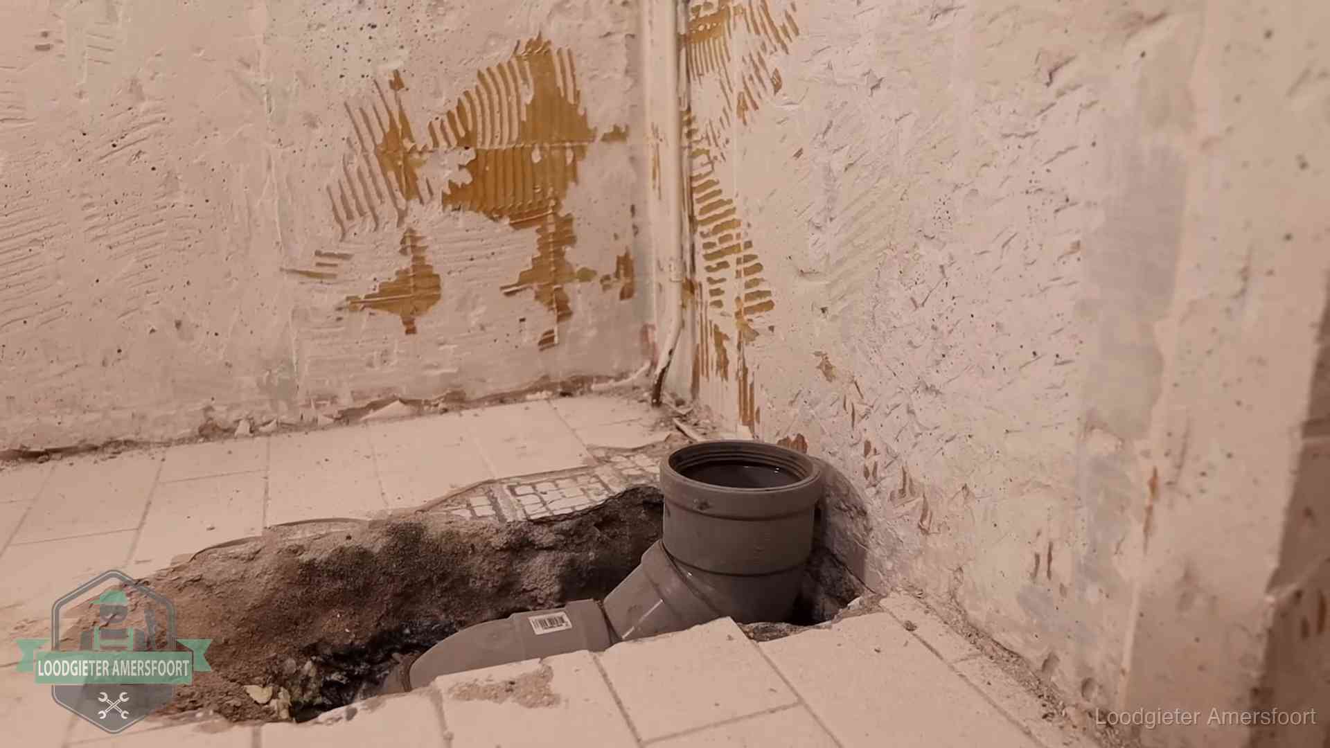 Opengebroken vloer met een nieuwe pvc-rioolbocht in een gegraven sleuf in Amersfoort