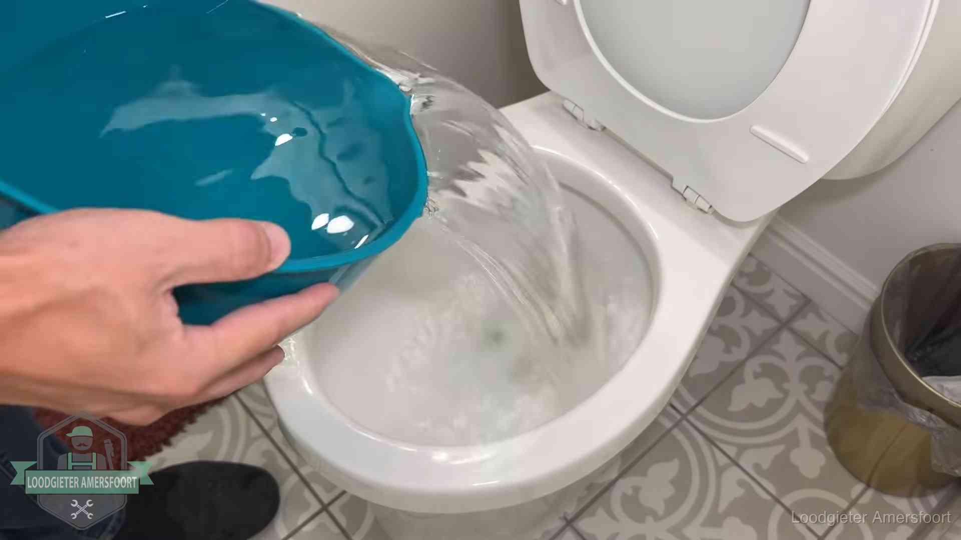 Warm water wordt voorzichtig in de wc-pot gegoten in Amersfoort