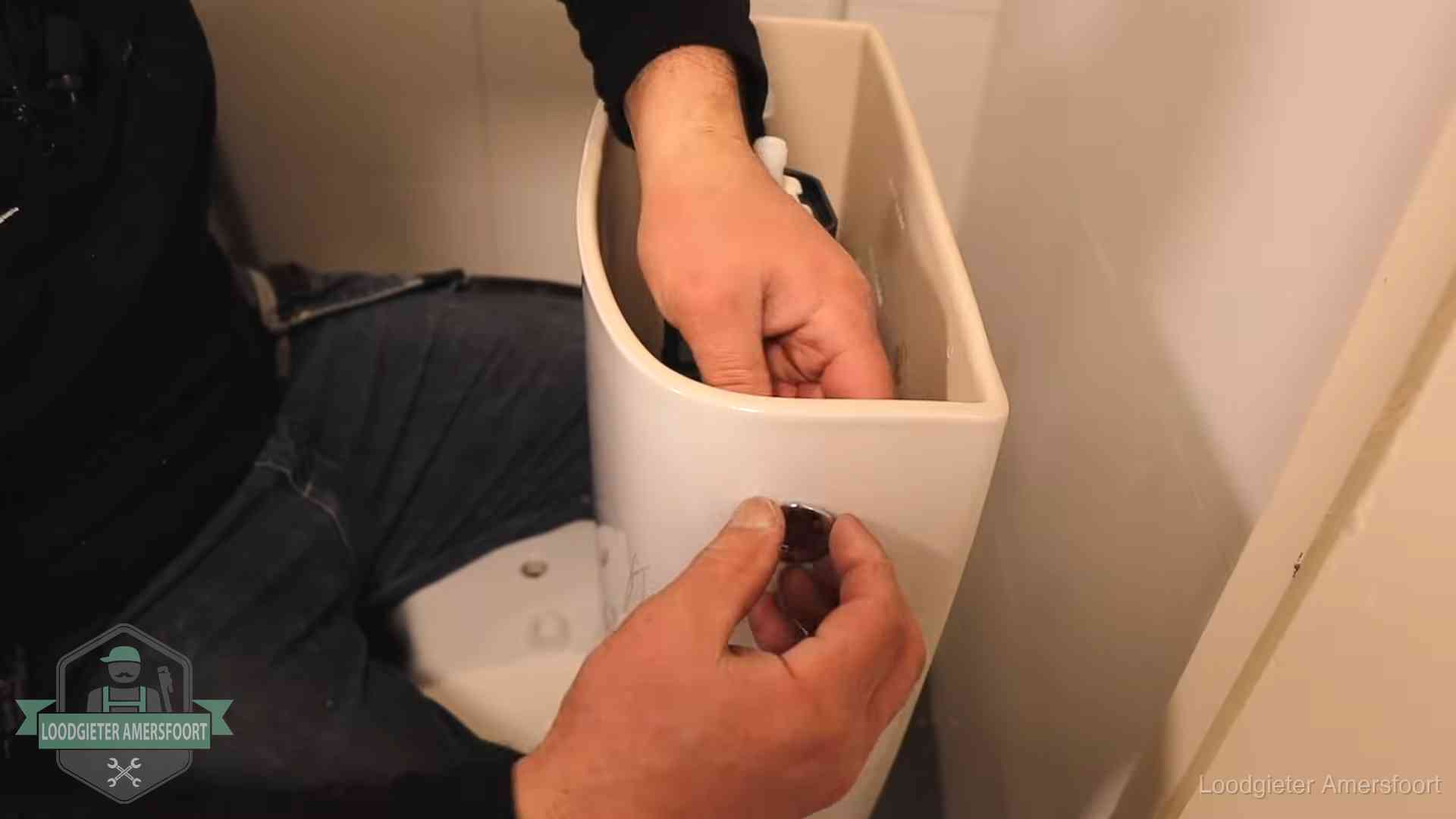 Drukknop van een duoblok-stortbak wordt gemonteerd bij een toilet in Amersfoort