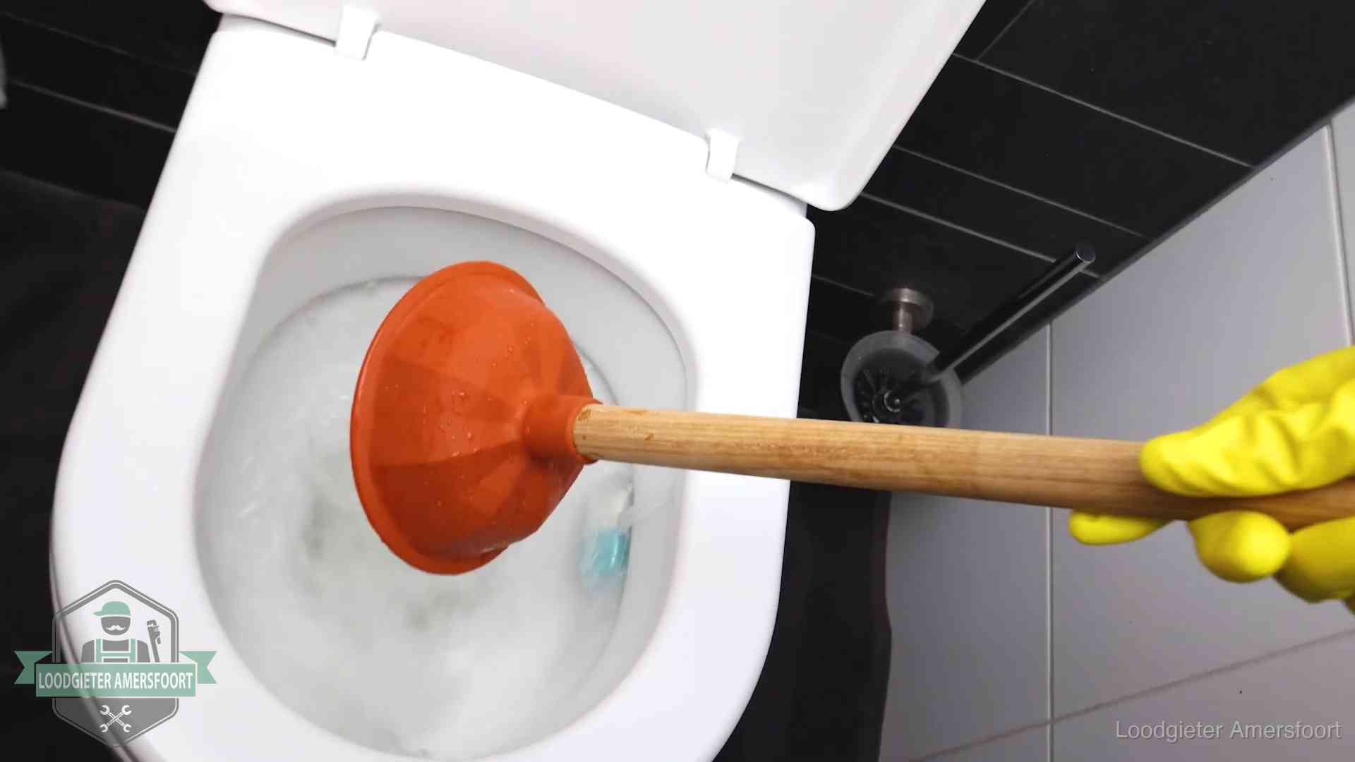 Plopper wordt in de wc-pot gedrukt bij het ontstoppen van een toilet in Amersfoort