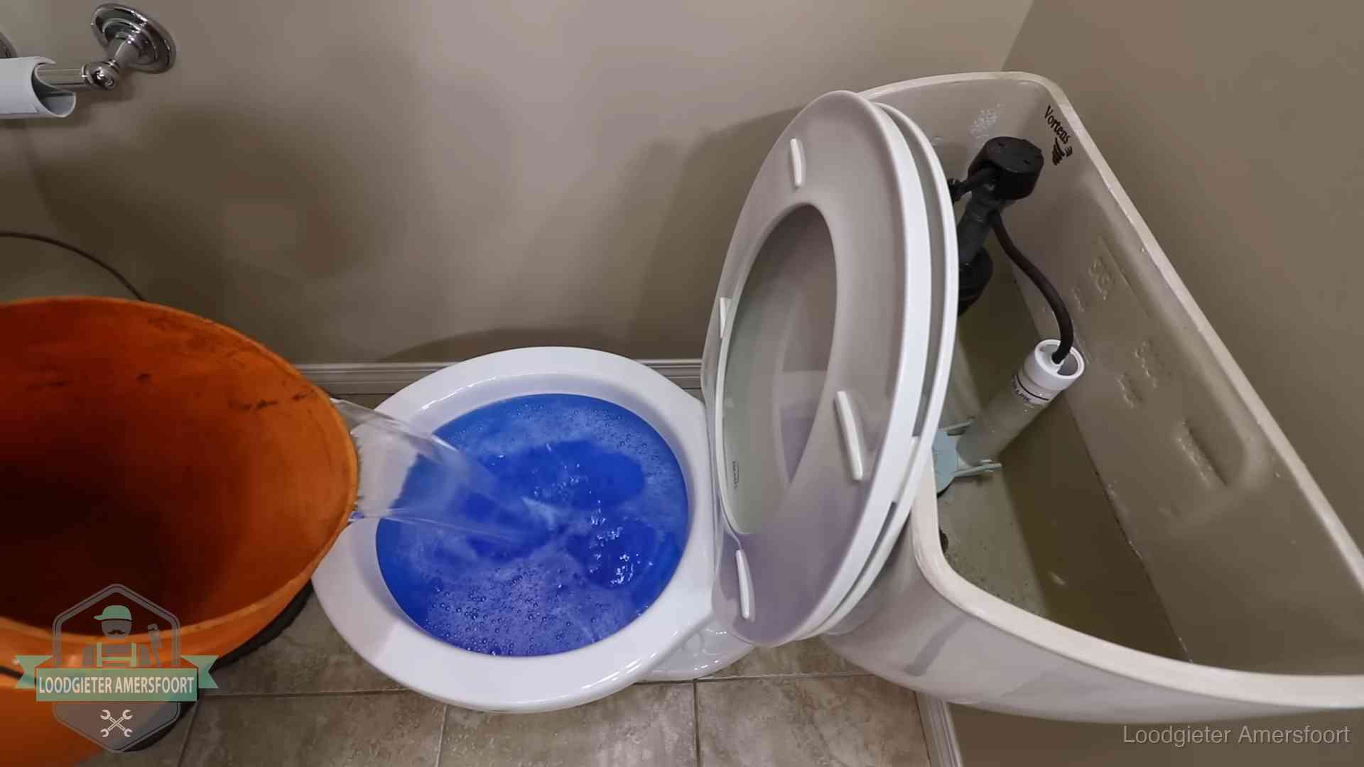 Water bij de wc-pot wordt met een emmer weggewerkt om schade te beperken in Amersfoort